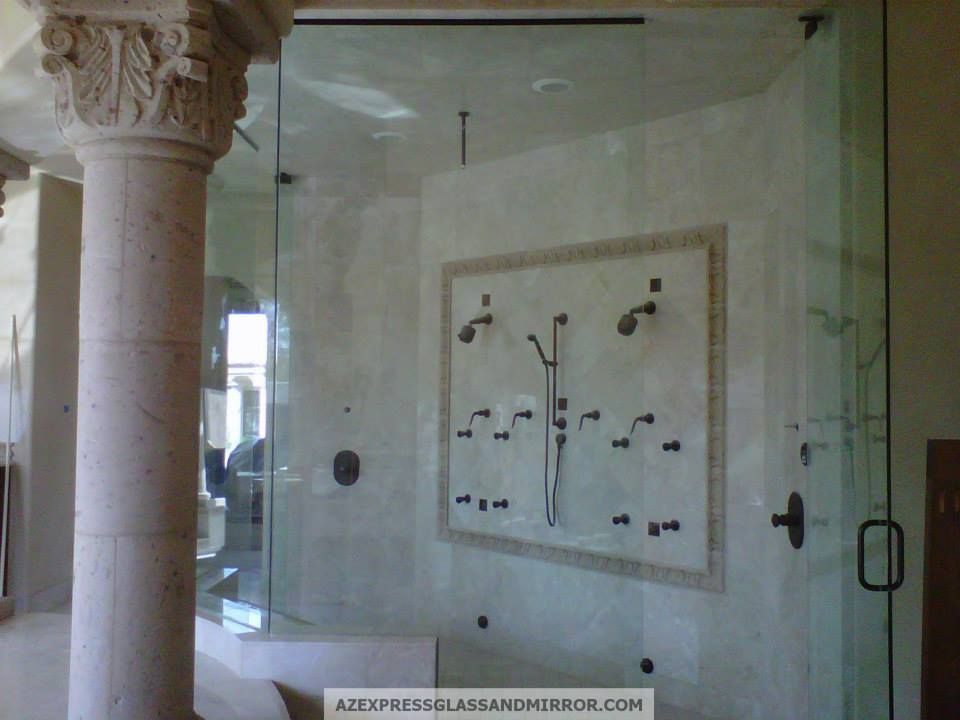 A bathroom with columns and a glass shower door