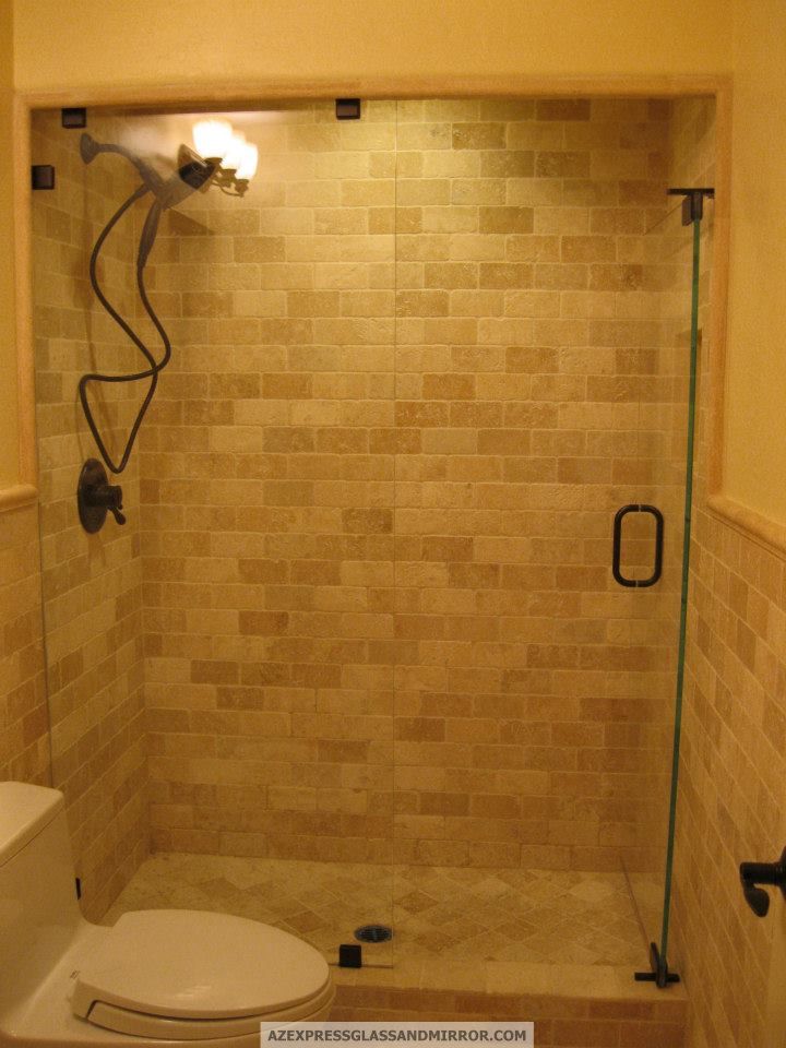 A bathroom with a toilet and a shower with a glass door