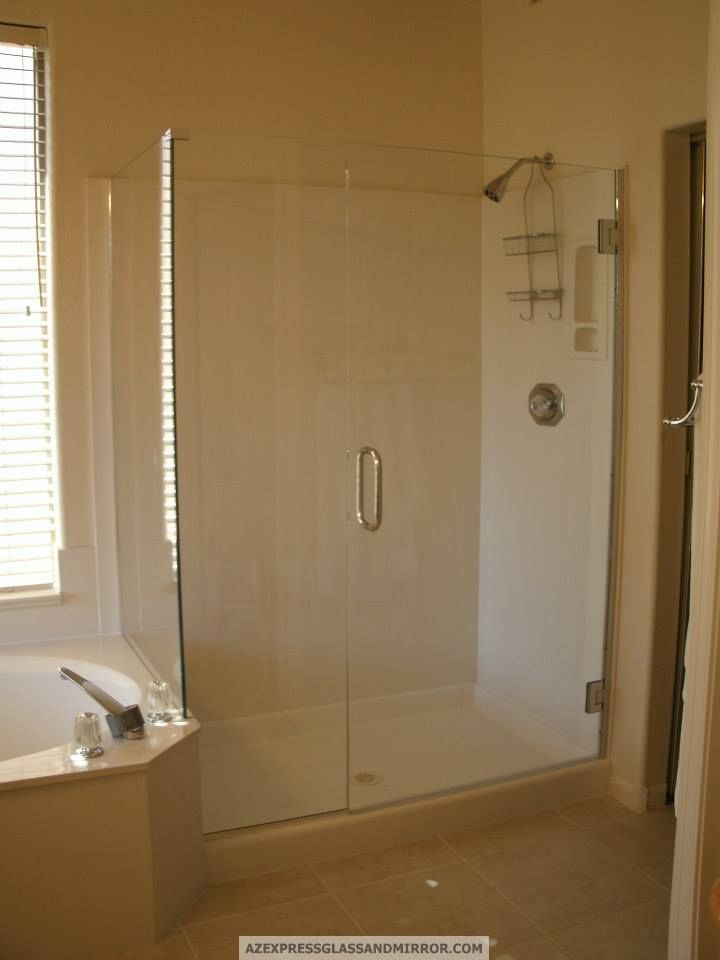 A bathroom with a walk in shower and a tub