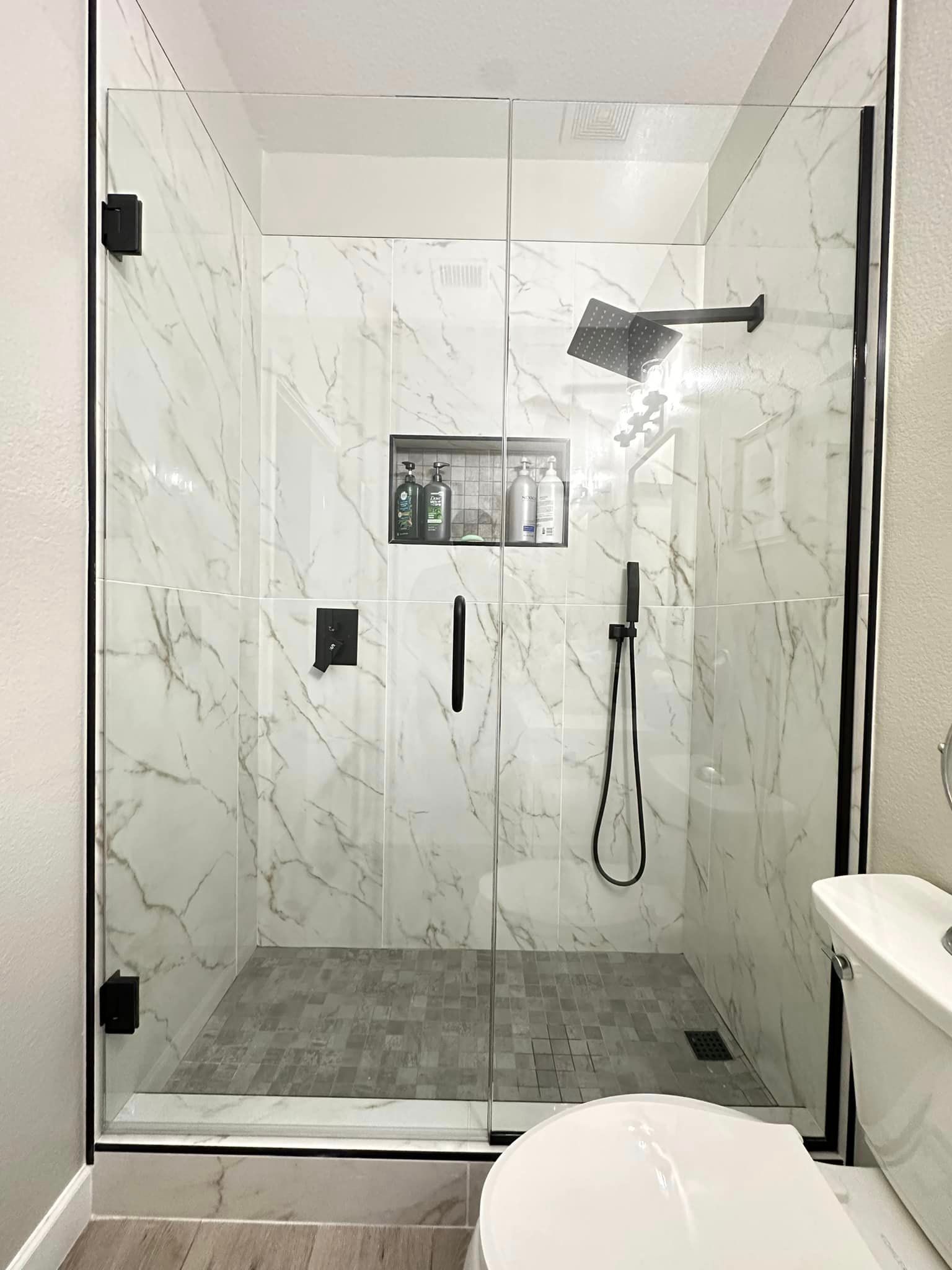 A bathroom with a walk in shower and a toilet.