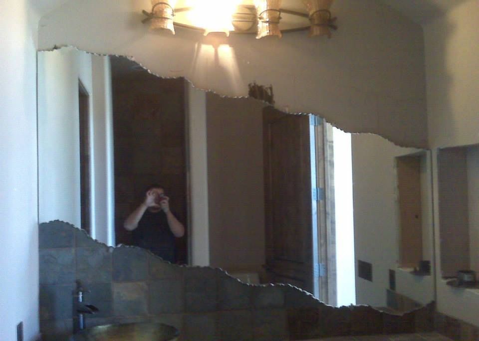 A bathroom with a large mirror and a sink