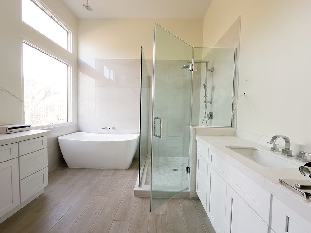 A bathroom with a bathtub and a walk in shower.