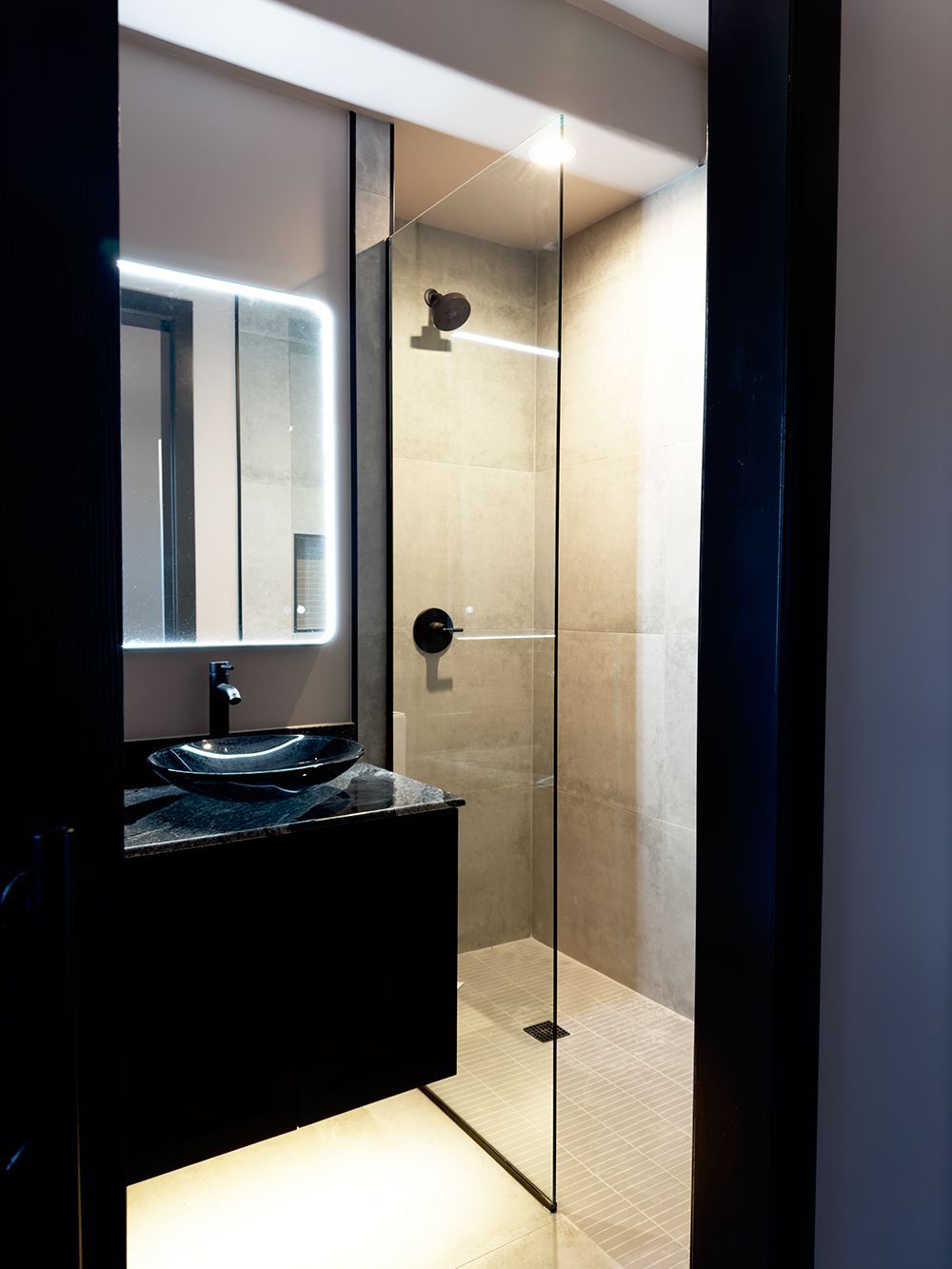 A bathroom with a sink, mirror, and walk in shower.