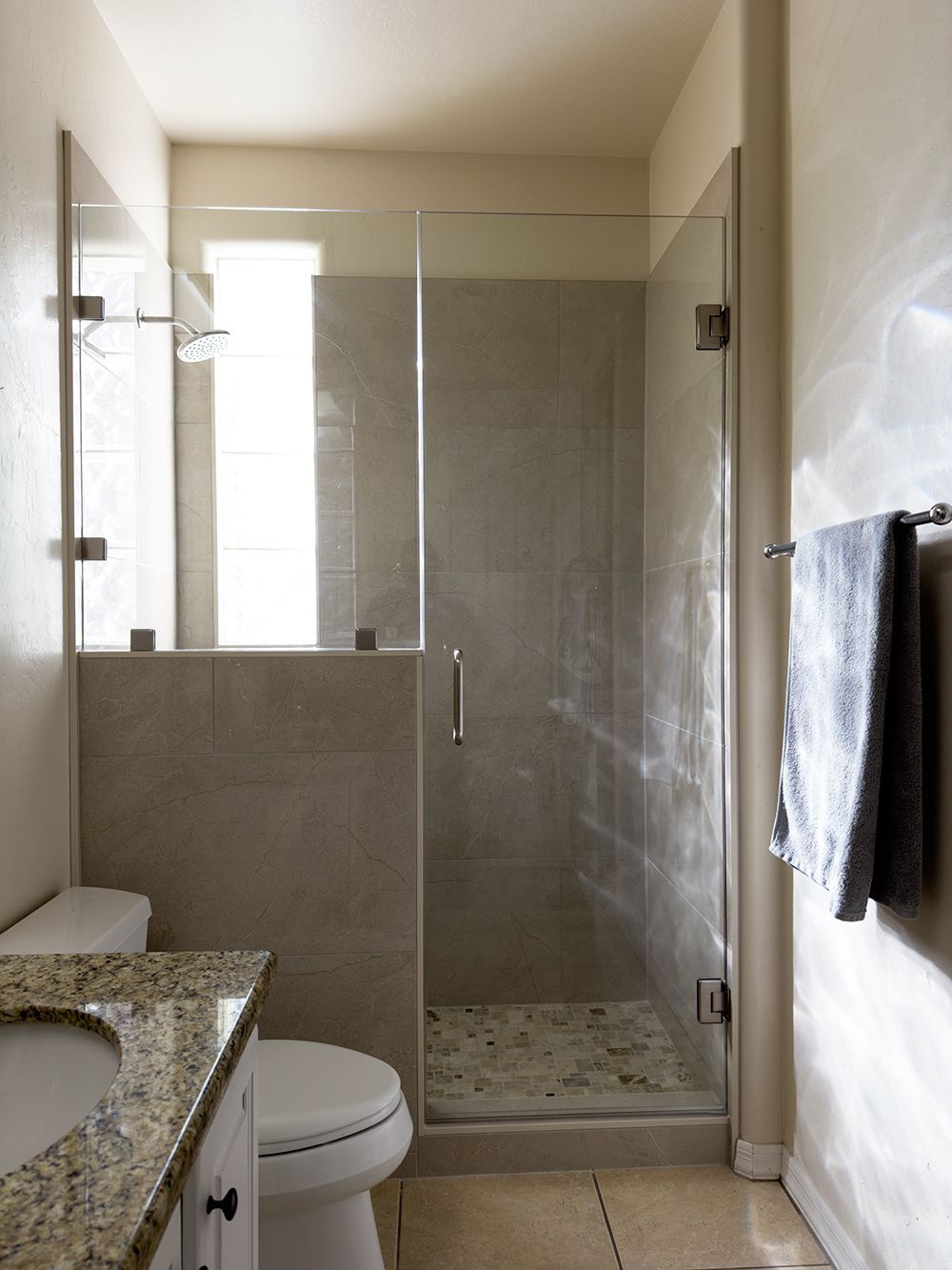 A bathroom with a toilet a sink and a walk in shower.