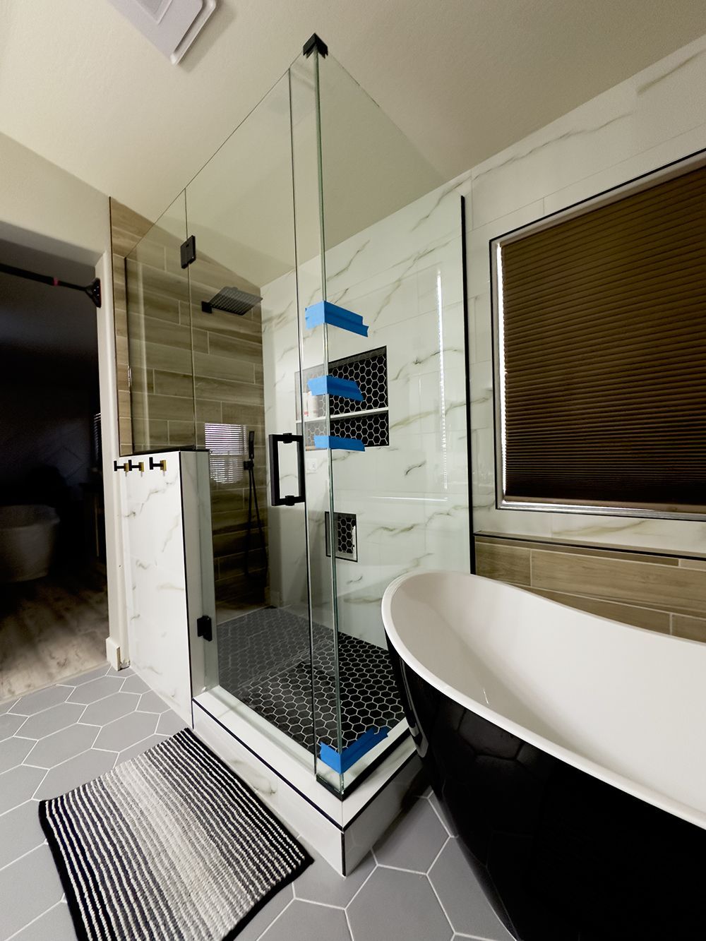 A bathroom with a tub , shower , and window.