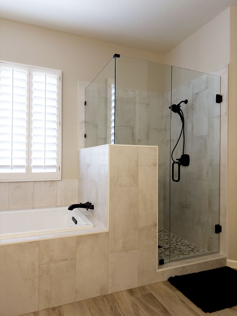 A bathroom with a tub and a walk in shower.