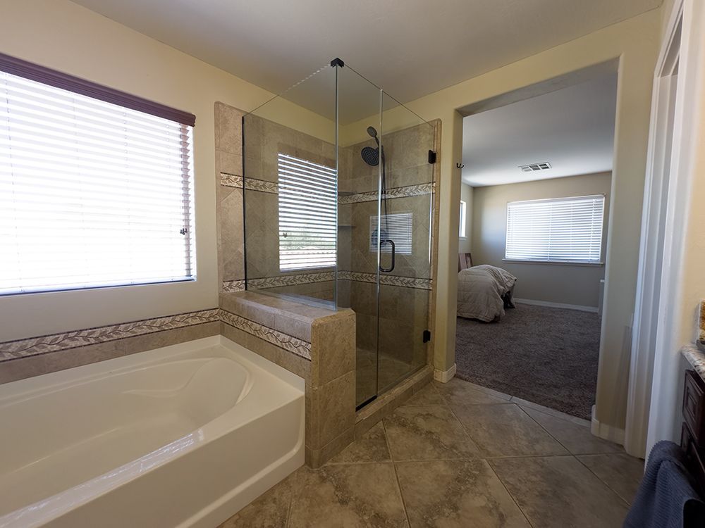 A bathroom with a bathtub and a walk in shower.