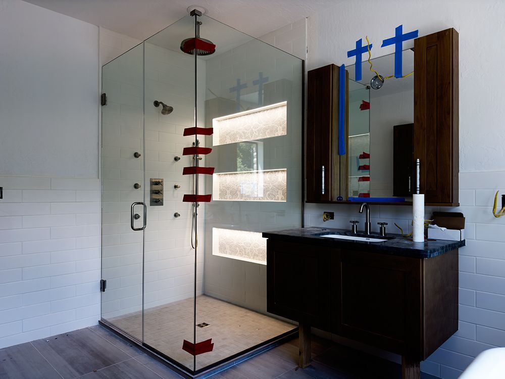 A bathroom with a walk in shower and a sink.
