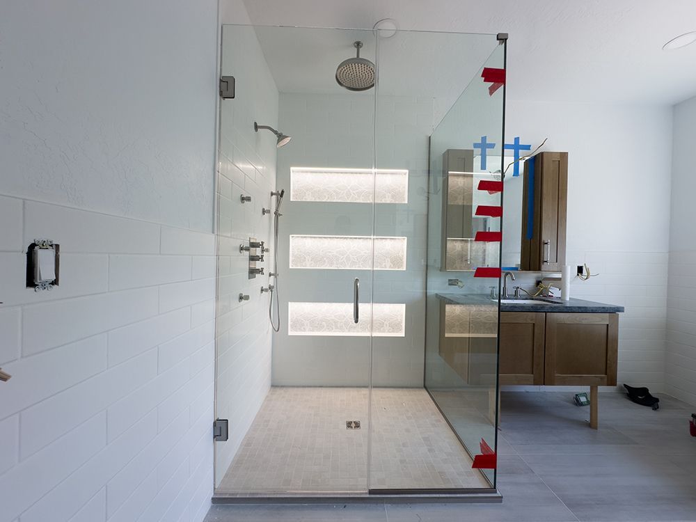 A bathroom with a walk in shower and a sink.
