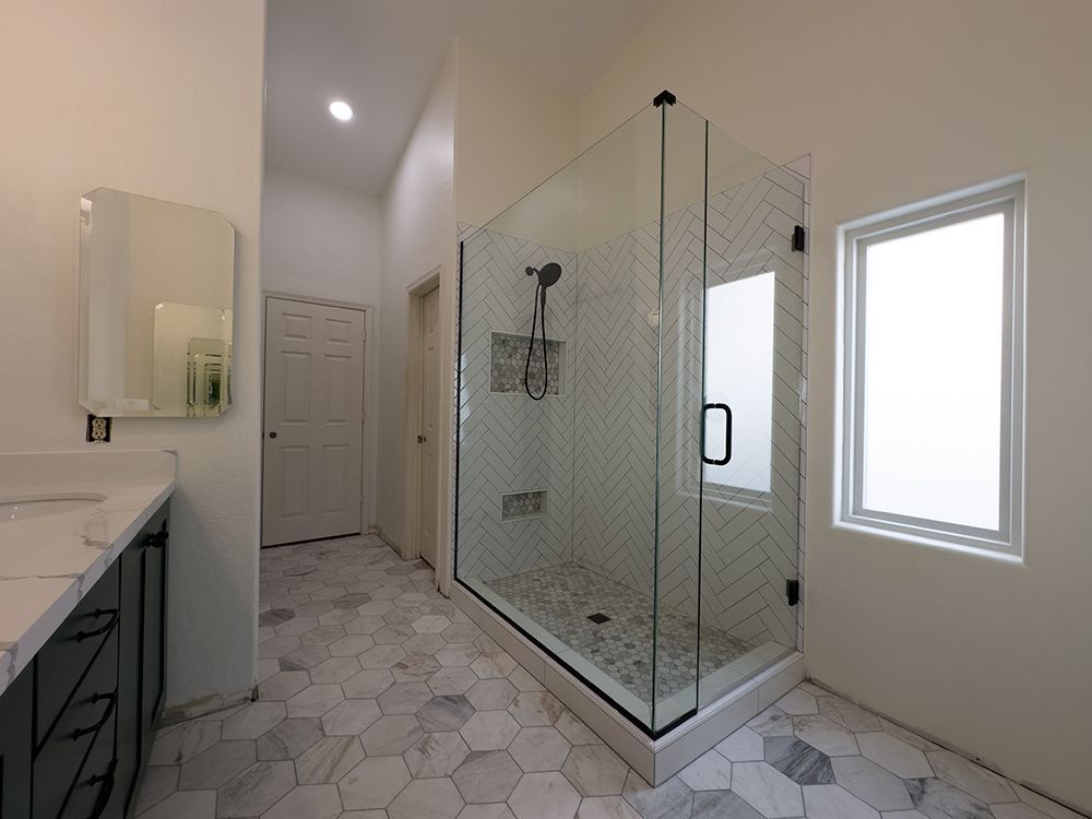 A bathroom with a walk in shower and two sinks.