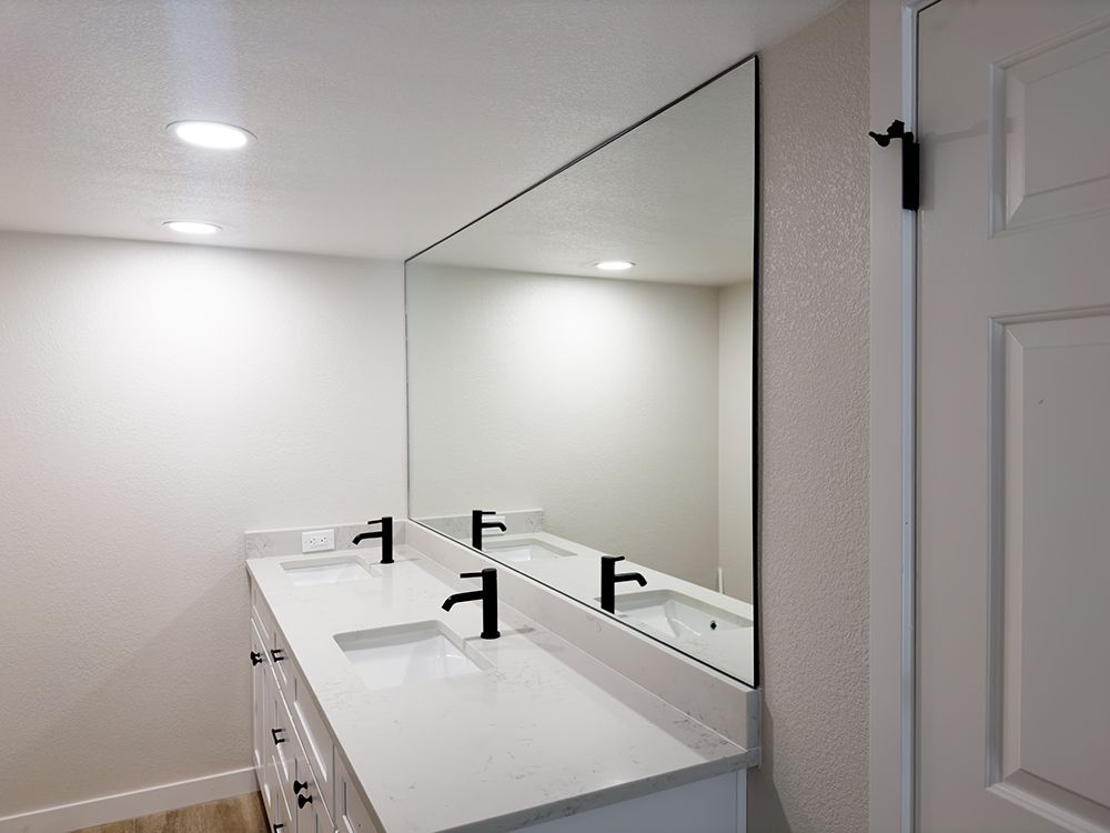 A bathroom with two sinks and a large mirror.