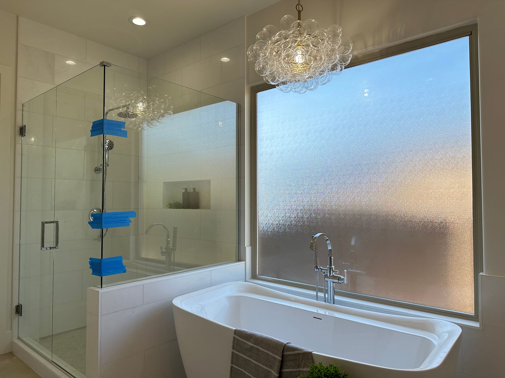 A bathroom with a tub, shower, and window.