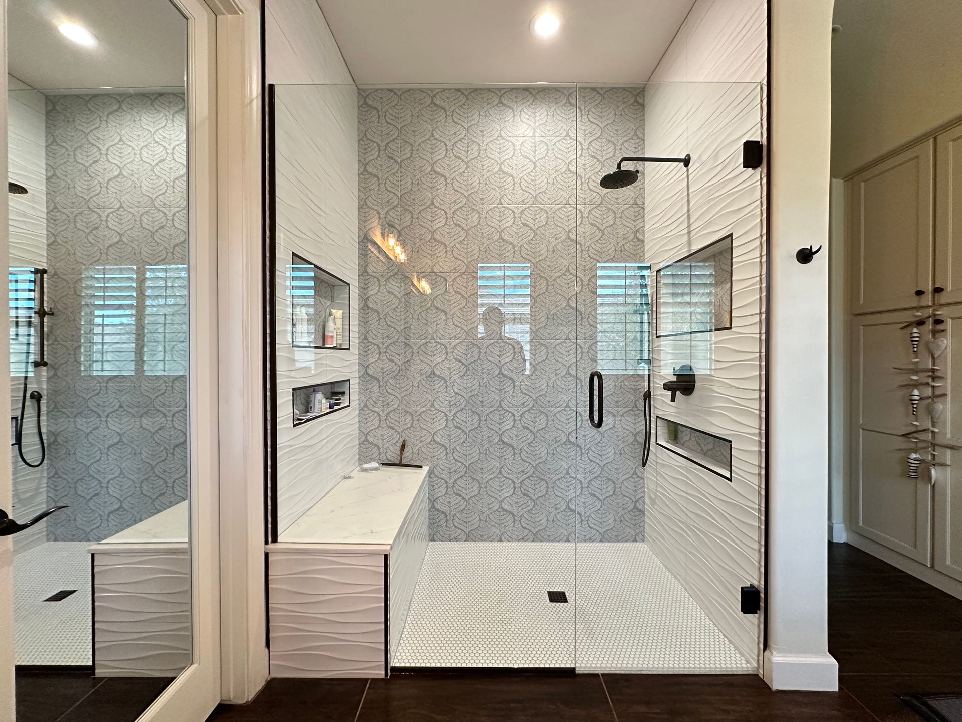 A bathroom with a walk in shower and a sink.