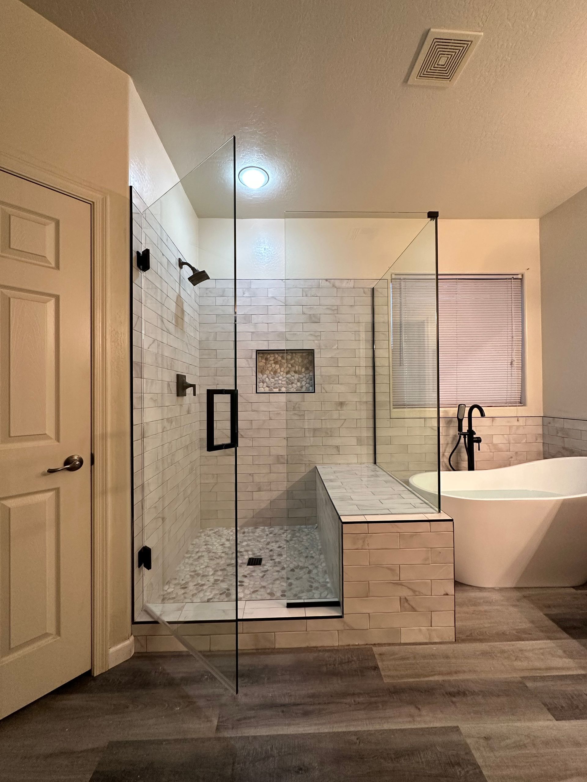 A bathroom with a walk in shower and a bathtub.