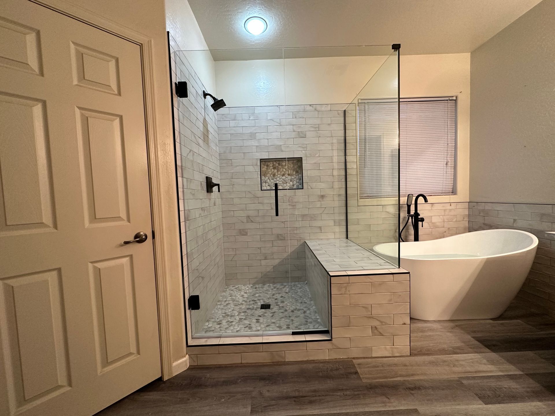 A bathroom with a tub, shower, and walk in shower.