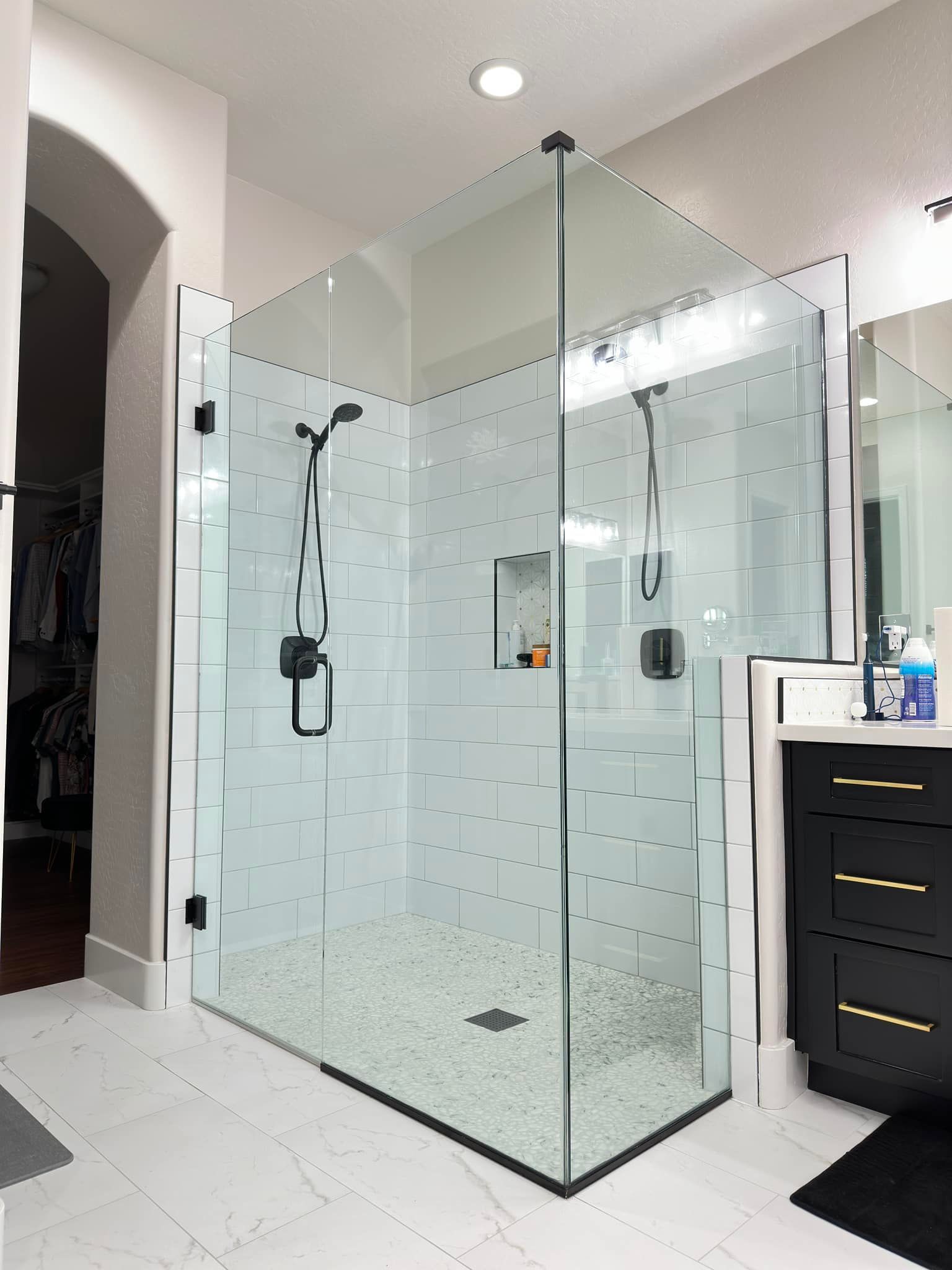 A bathroom with a walk in shower and a sink.