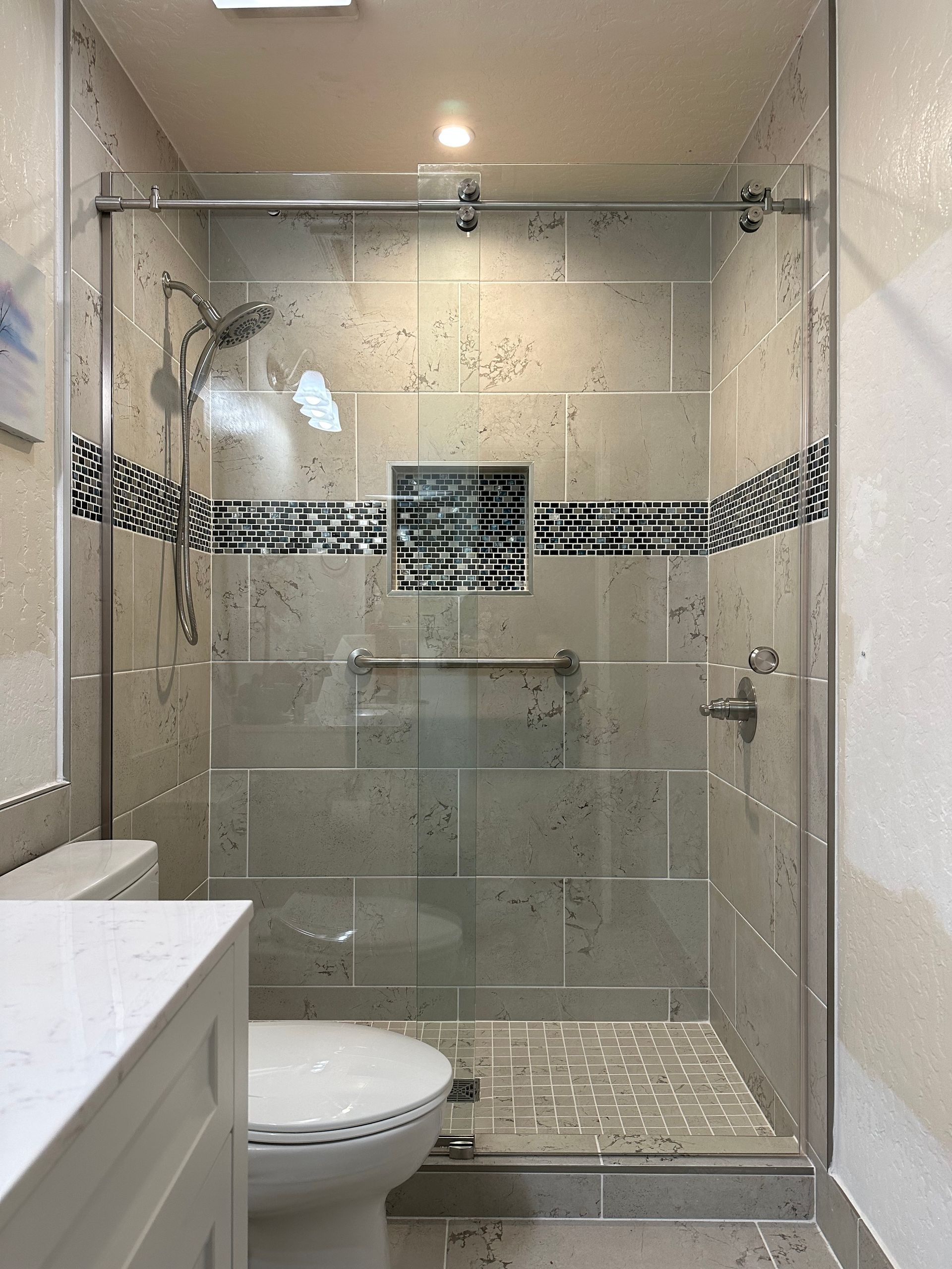 A bathroom with a sliding glass shower door, toilet and sink.