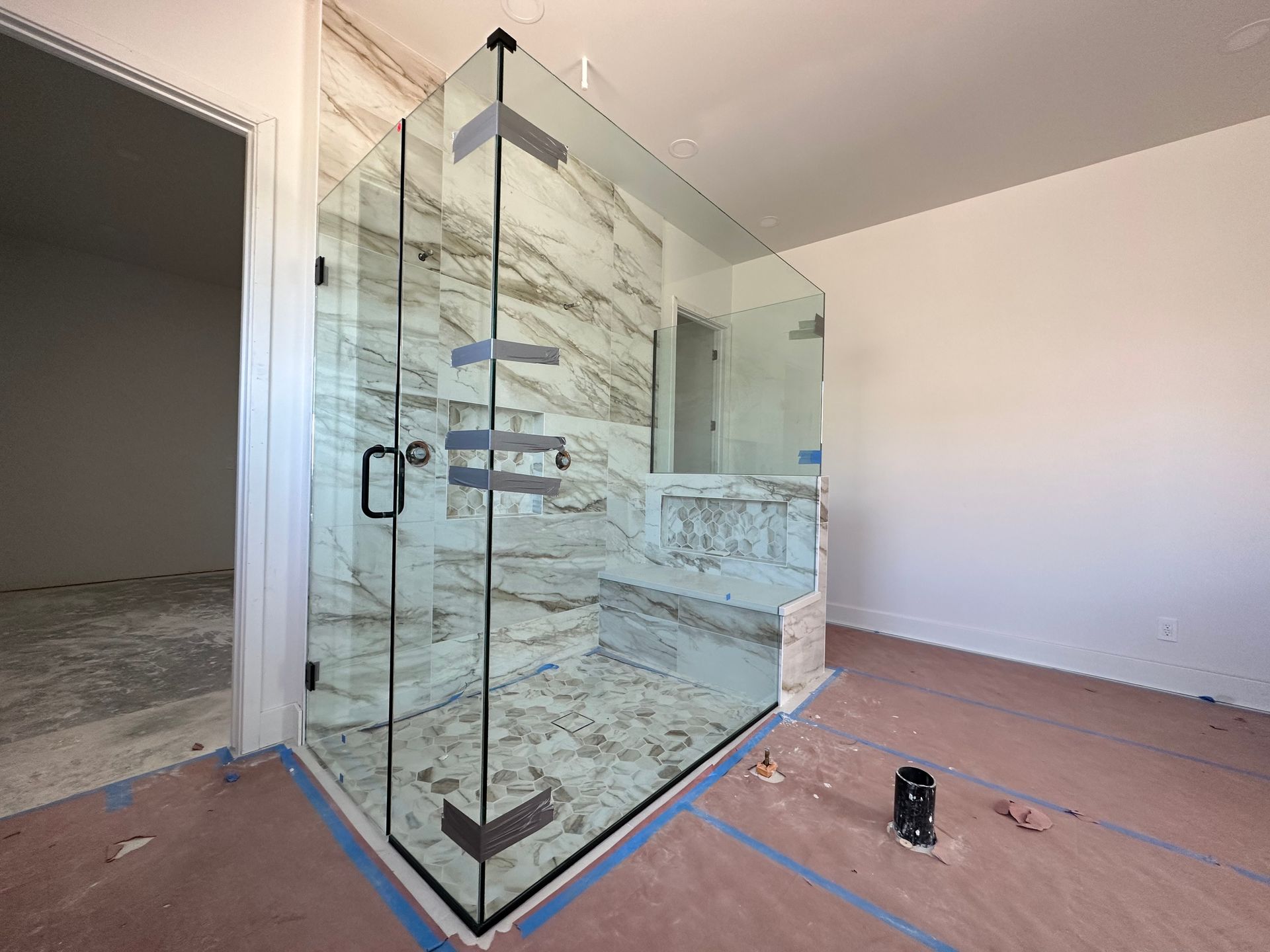 A bathroom with a walk in shower and a marble wall.