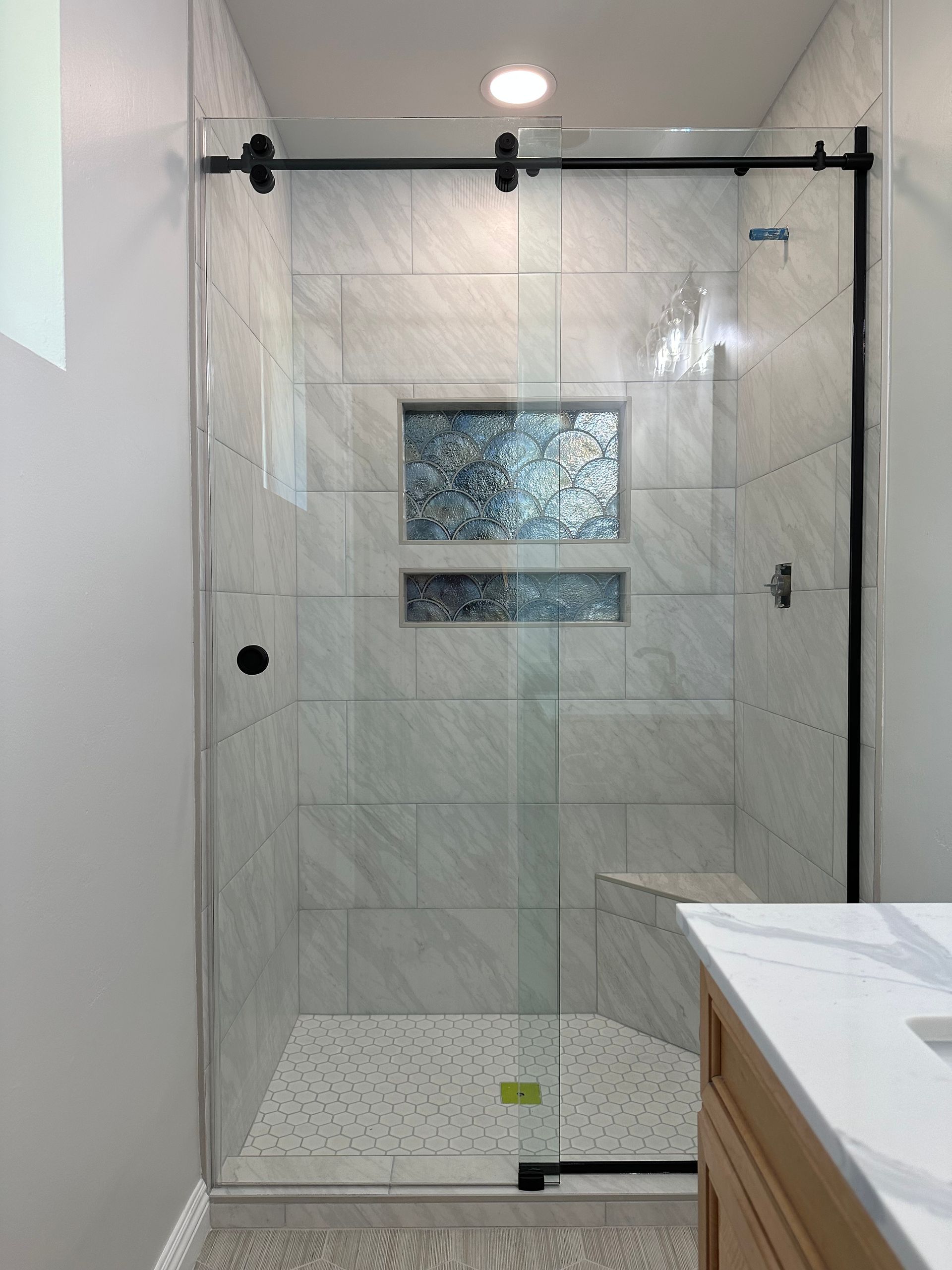 A bathroom with a sliding glass shower door and a sink.