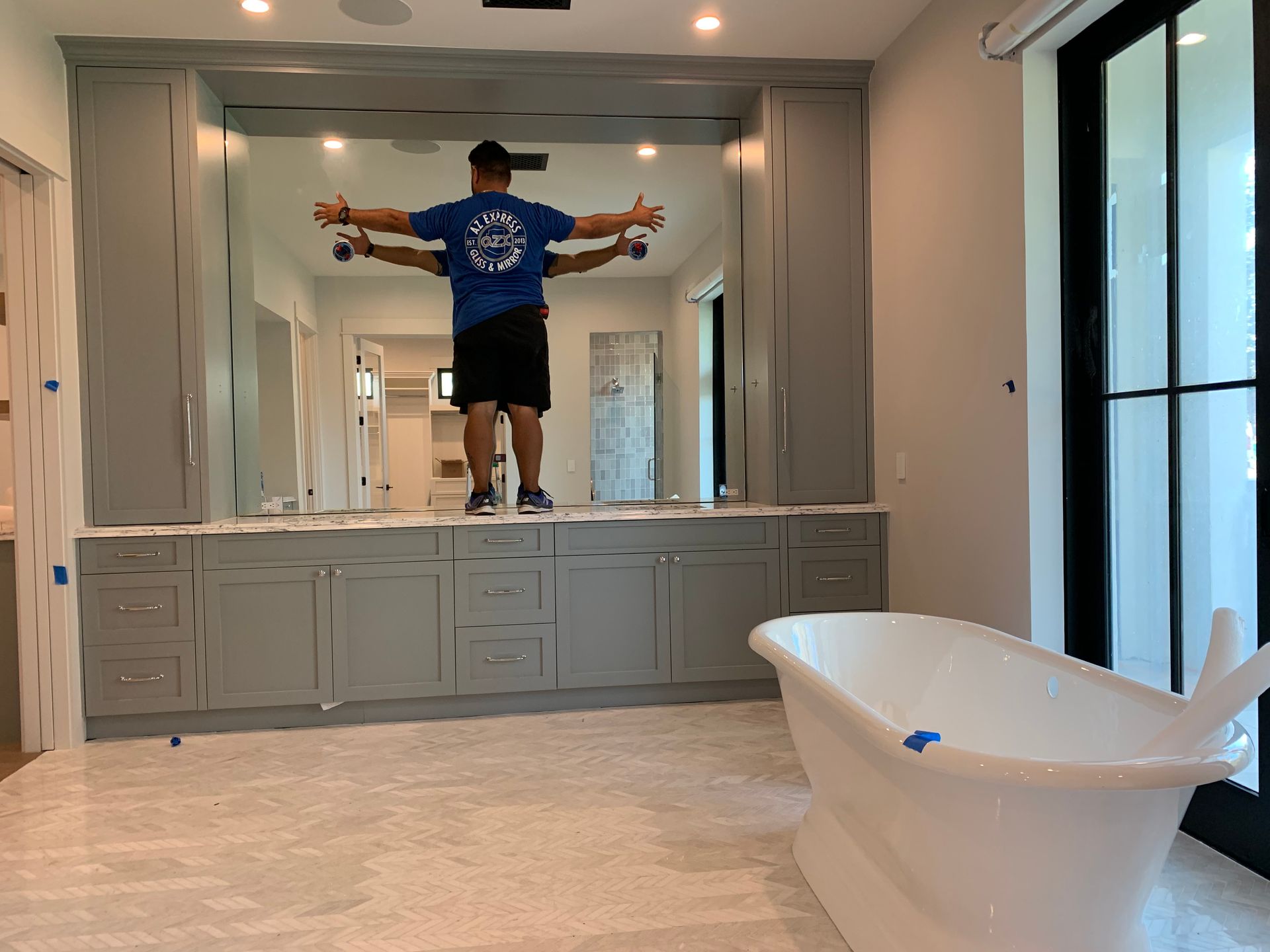 A man is standing in a bathroom next to a bathtub.