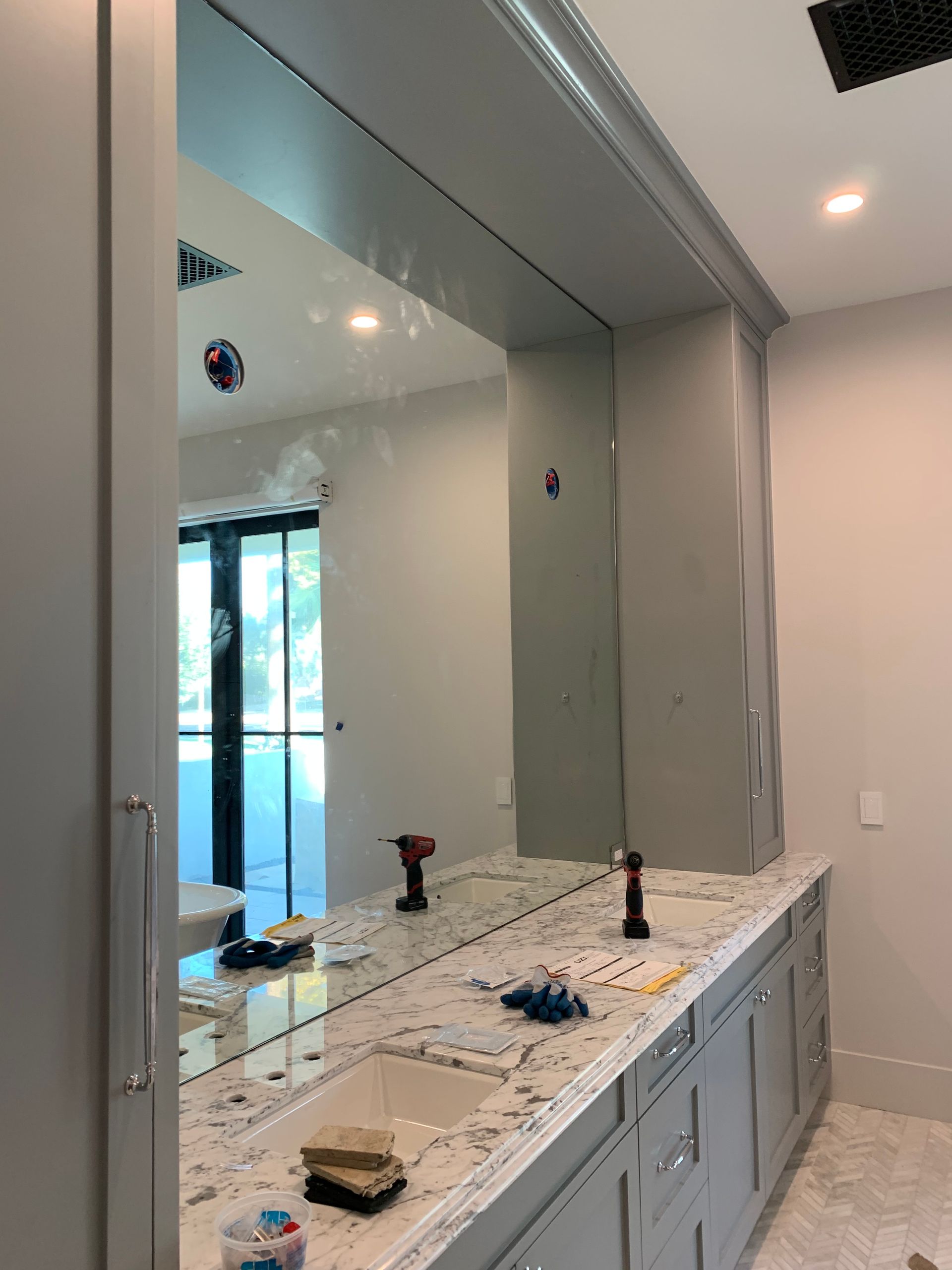 A bathroom with a large mirror and a sink.