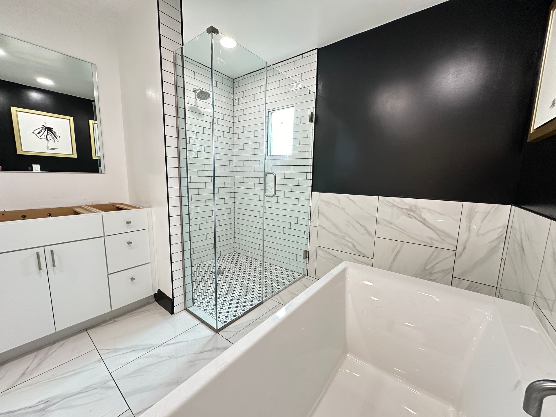A bathroom with a bathtub and a walk in shower.