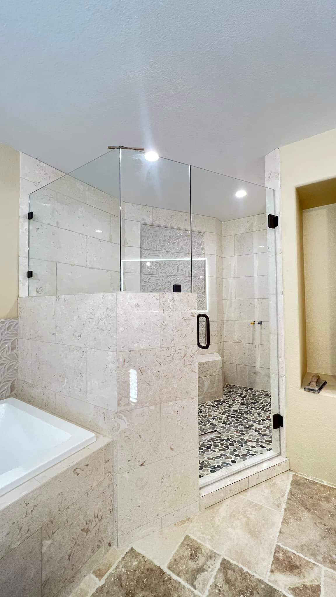 A bathroom with a walk in shower and a bathtub.