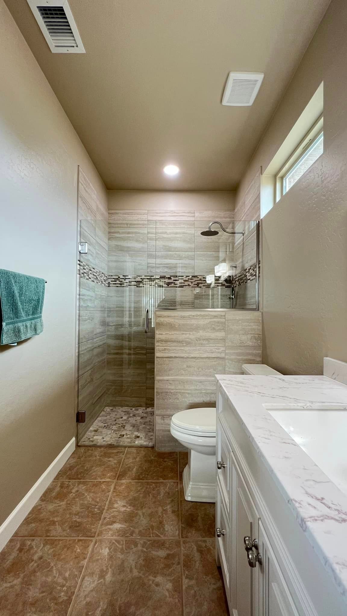 A bathroom with a toilet, sink, and walk-in shower.