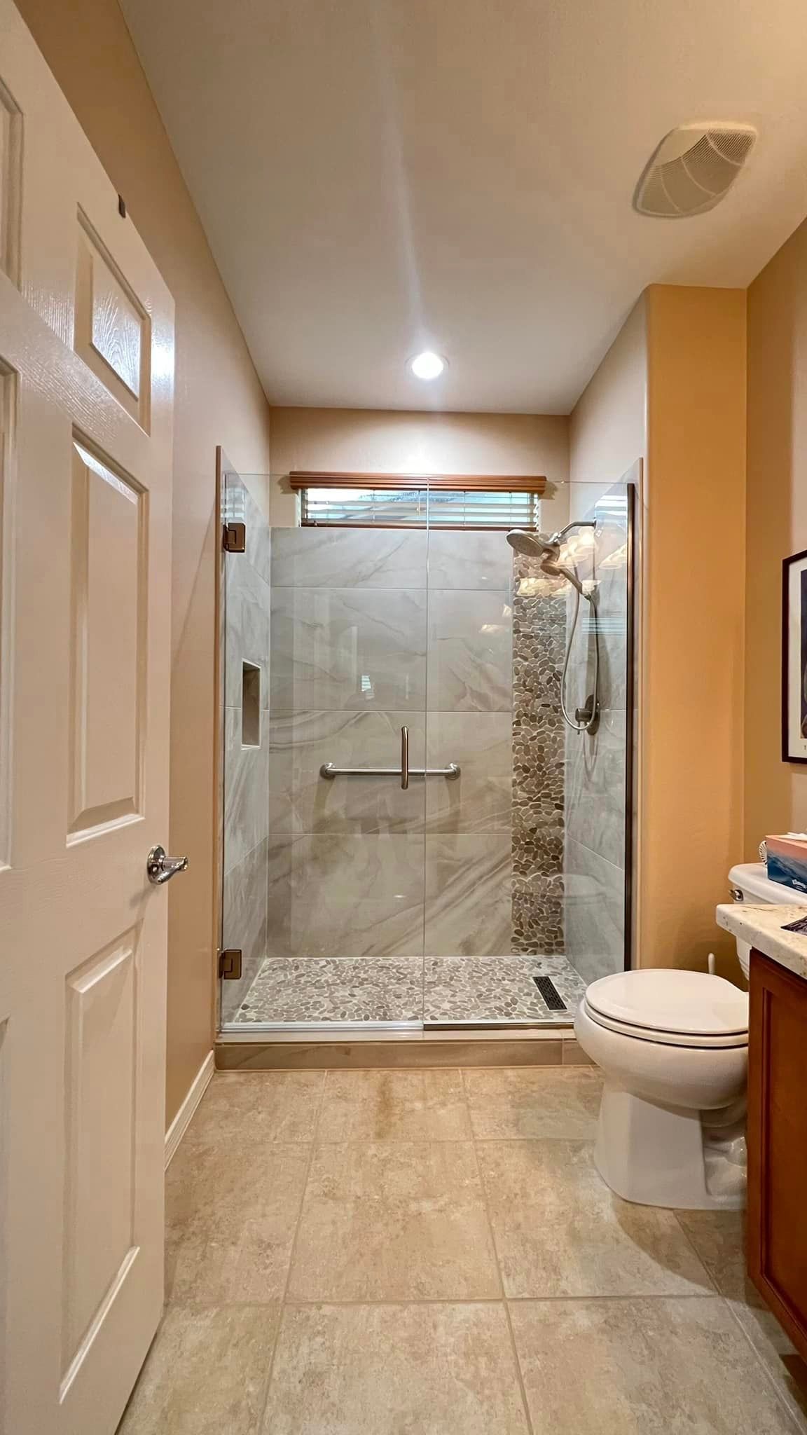 A bathroom with a toilet, sink, and walk-in shower.