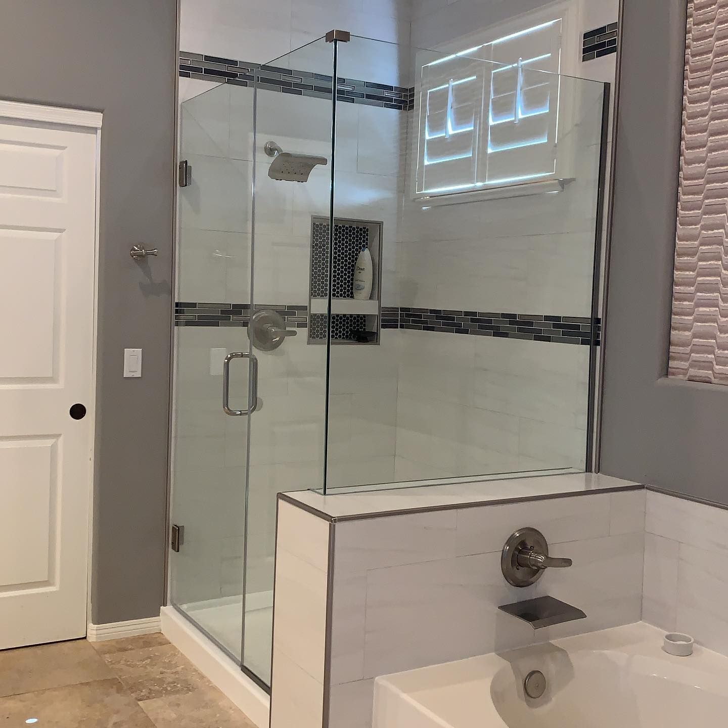 A bathroom with a tub and a shower with a glass door