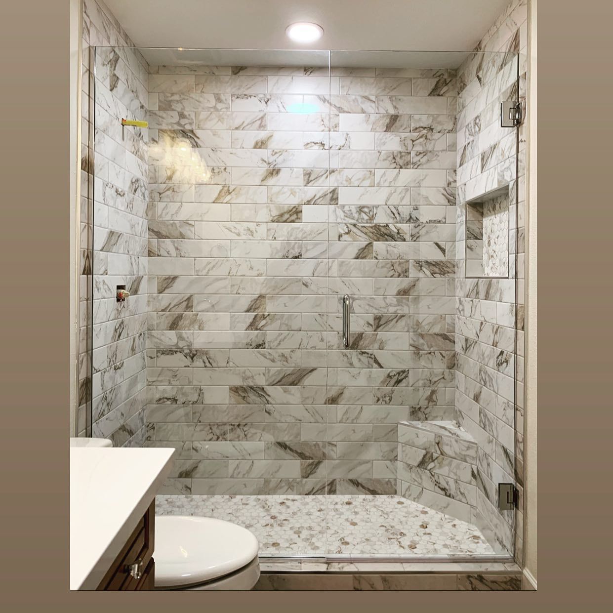 A bathroom with a walk in shower and a toilet.