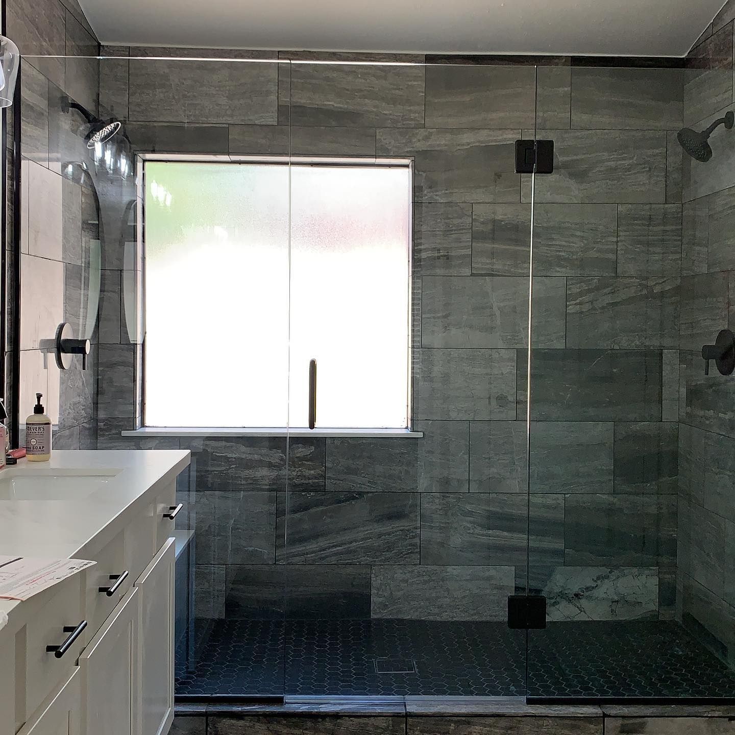A bathroom with a walk in shower and a window