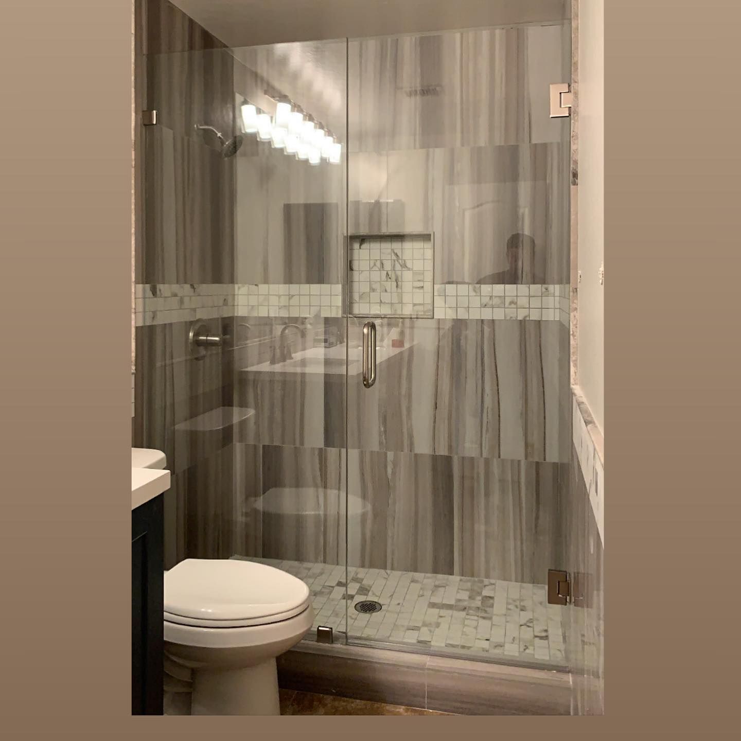 A bathroom with a toilet and a shower stall with a glass door.