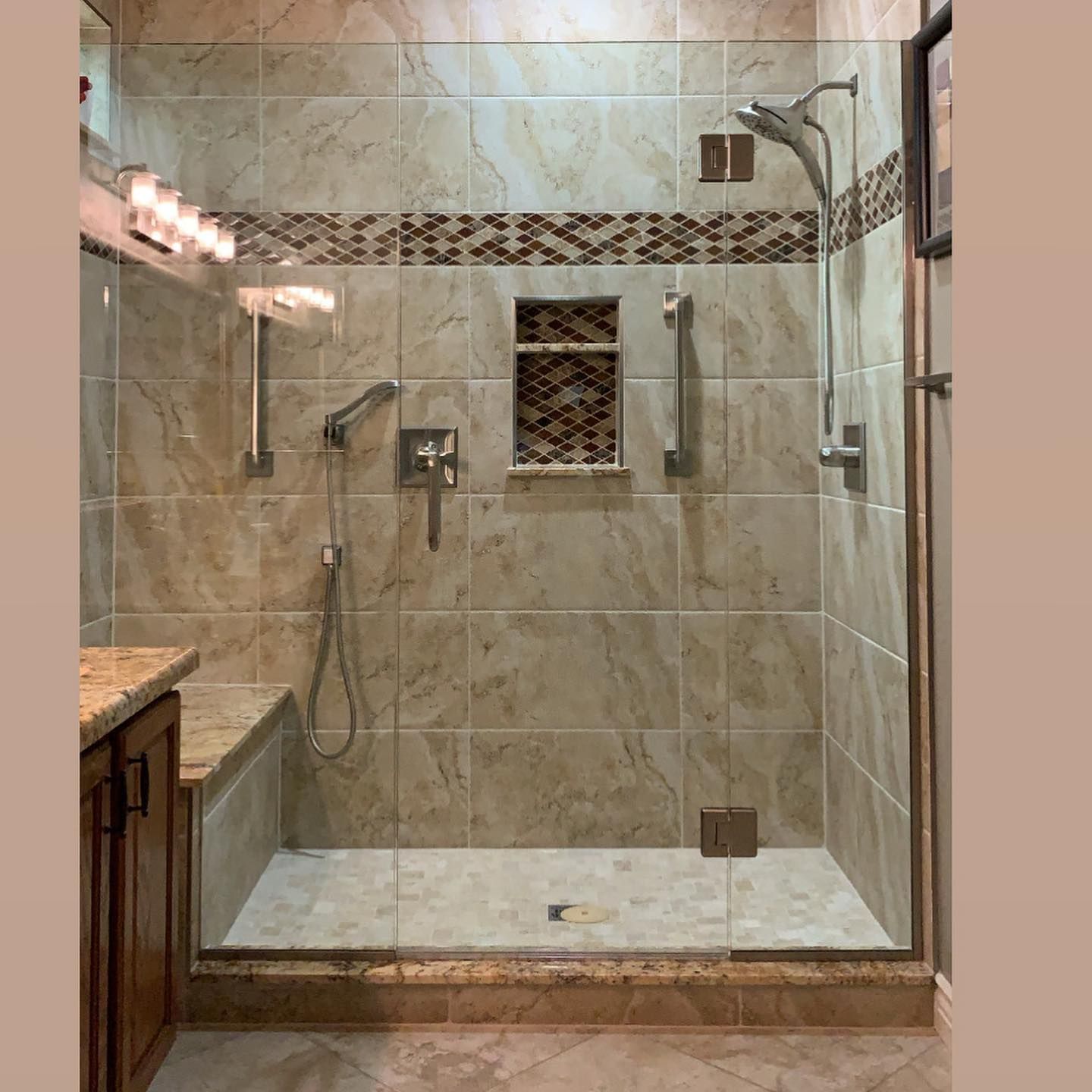 A bathroom with a walk in shower with a glass door