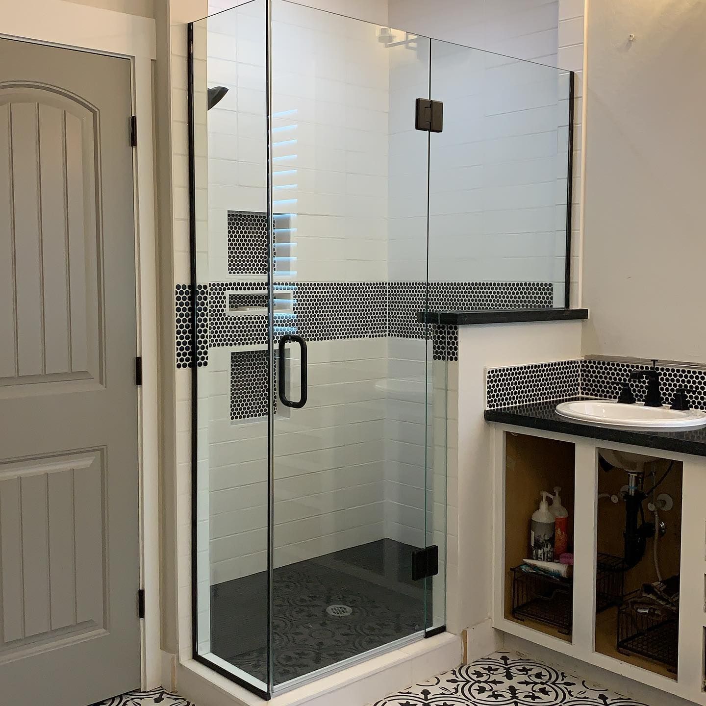 A bathroom with a walk in shower and a sink.
