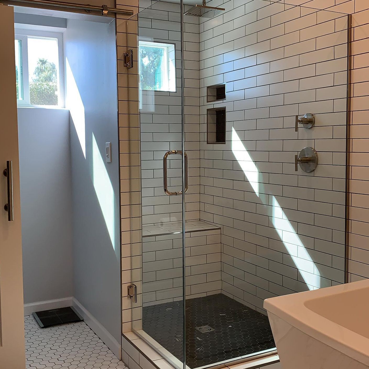 A bathroom with white brick walls and a glass shower