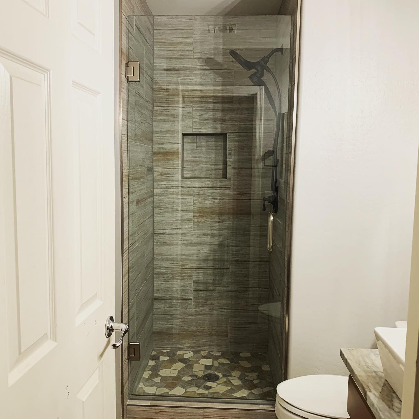 A bathroom with a walk in shower and a toilet