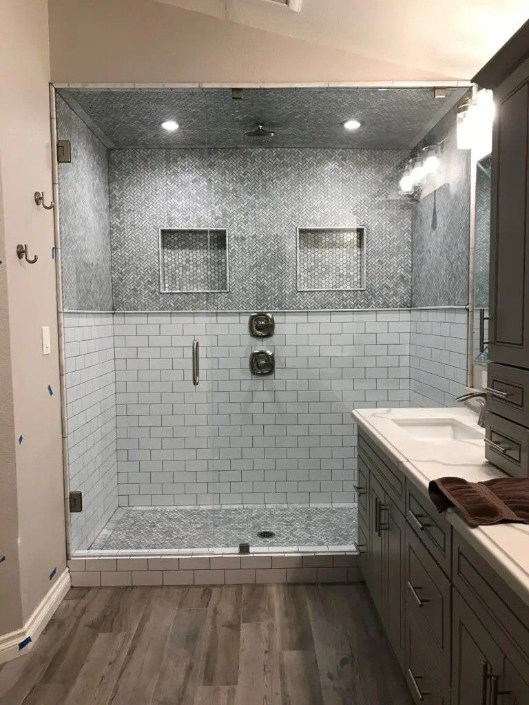 A bathroom with a walk in shower and a sink.