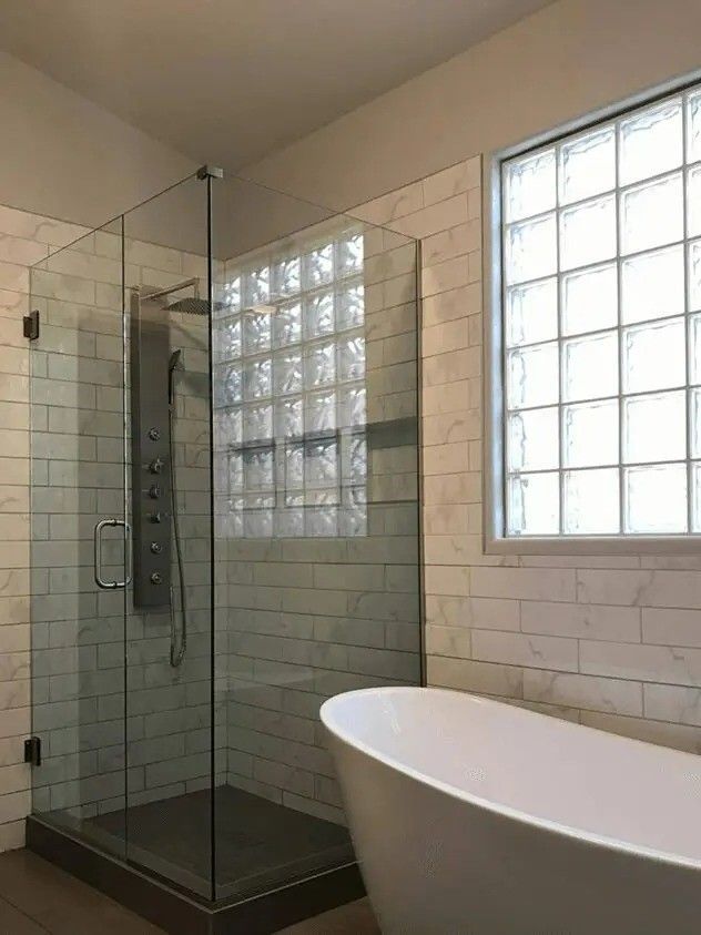 A bathroom with a walk in shower and a bathtub.