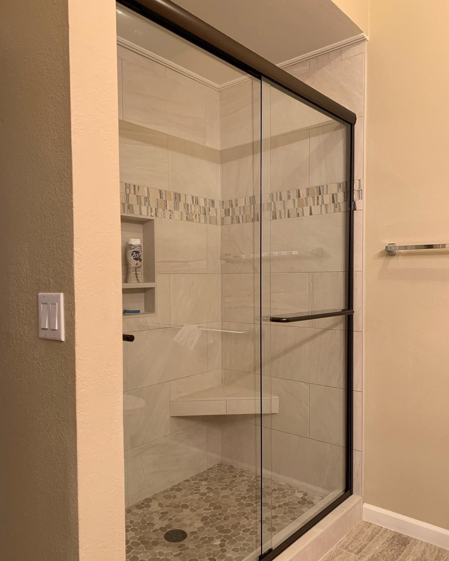 A bathroom with a sliding glass shower door.