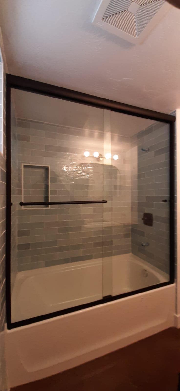 A bathroom with a bathtub and a shower with a glass door.