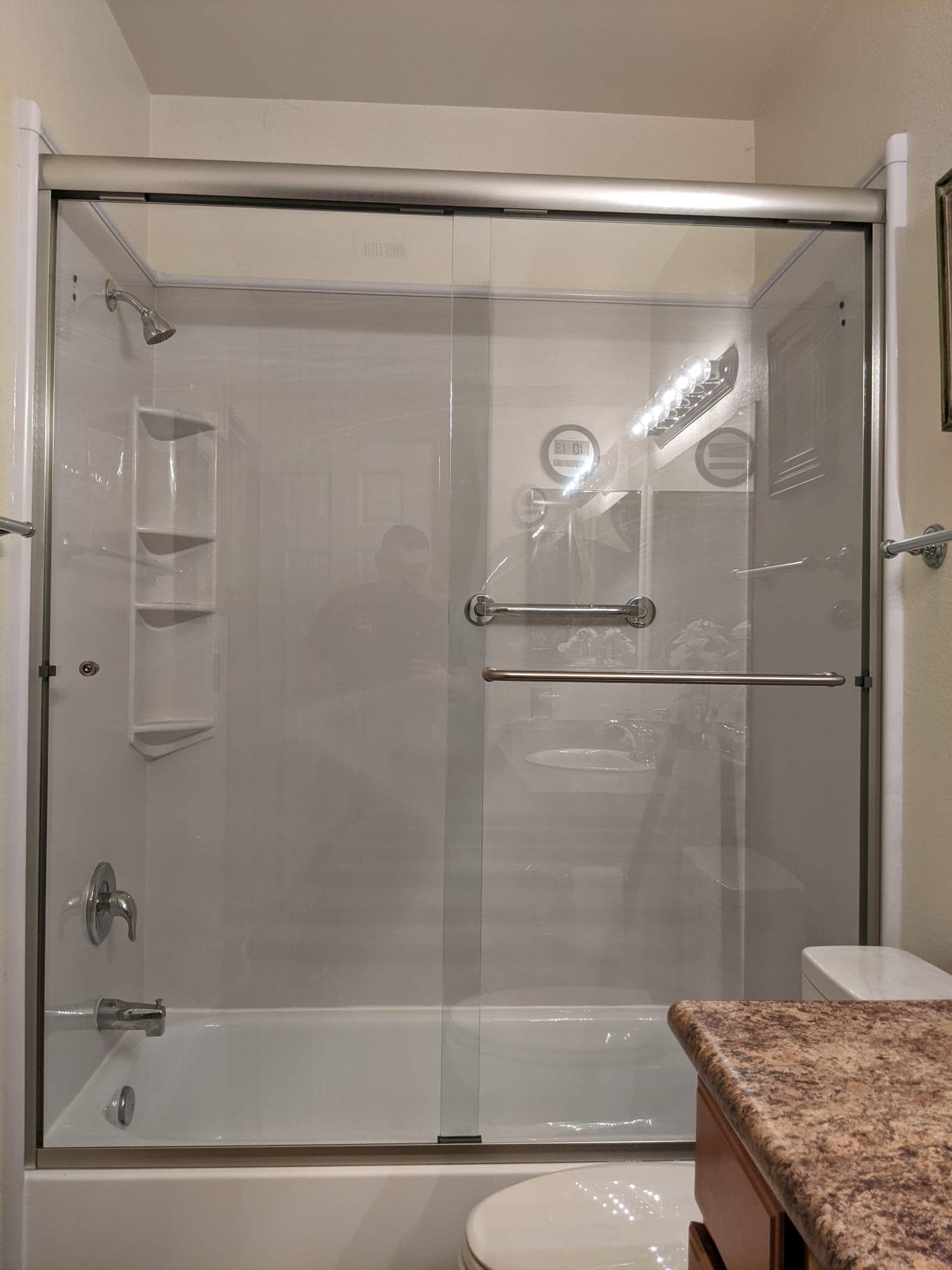 A bathroom with a sliding glass shower door and a bathtub.