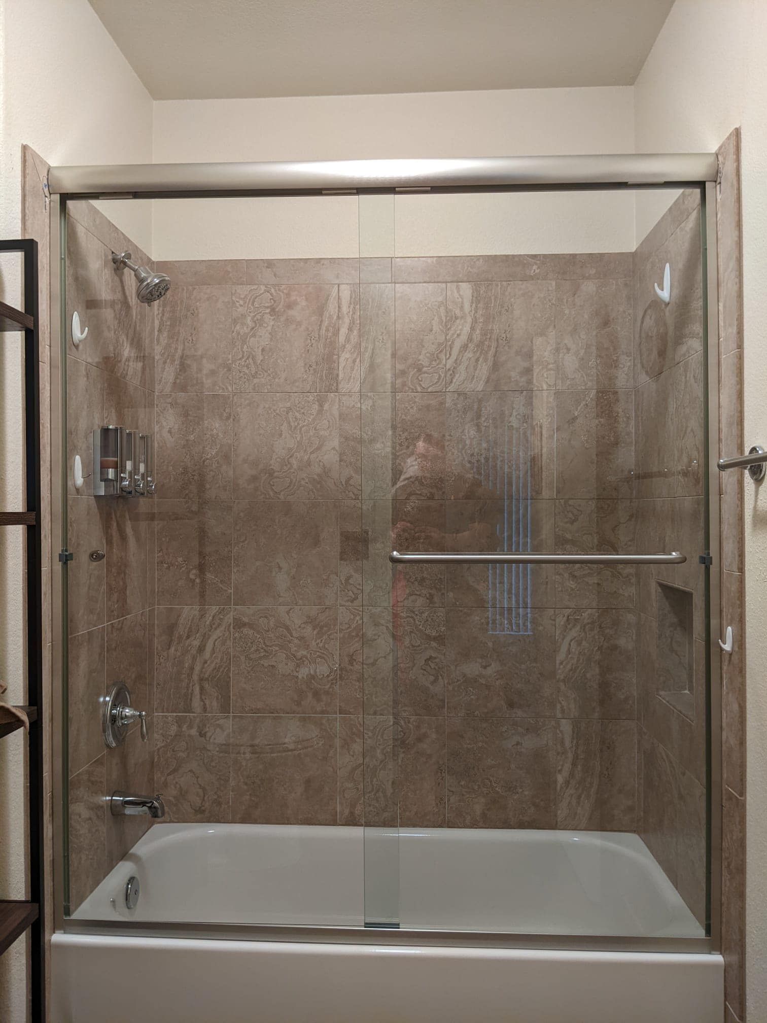 A bathroom with a tub and a shower with a sliding glass door.
