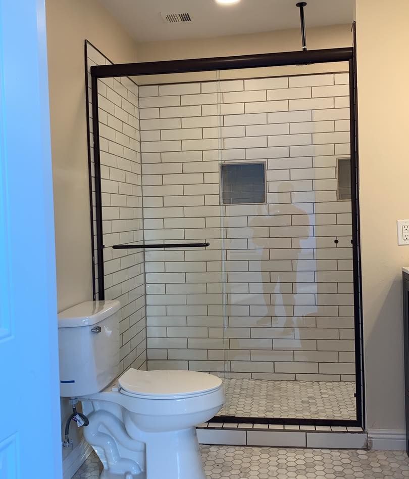 A bathroom with a toilet and a walk in shower