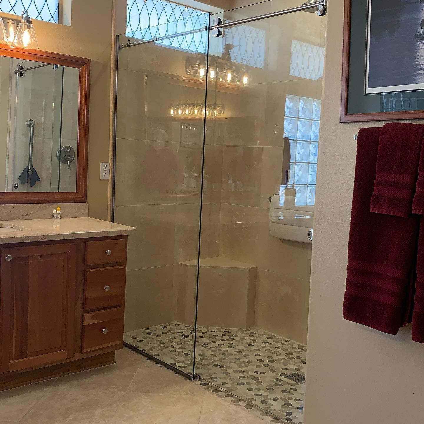 A bathroom with a walk in shower and a sink