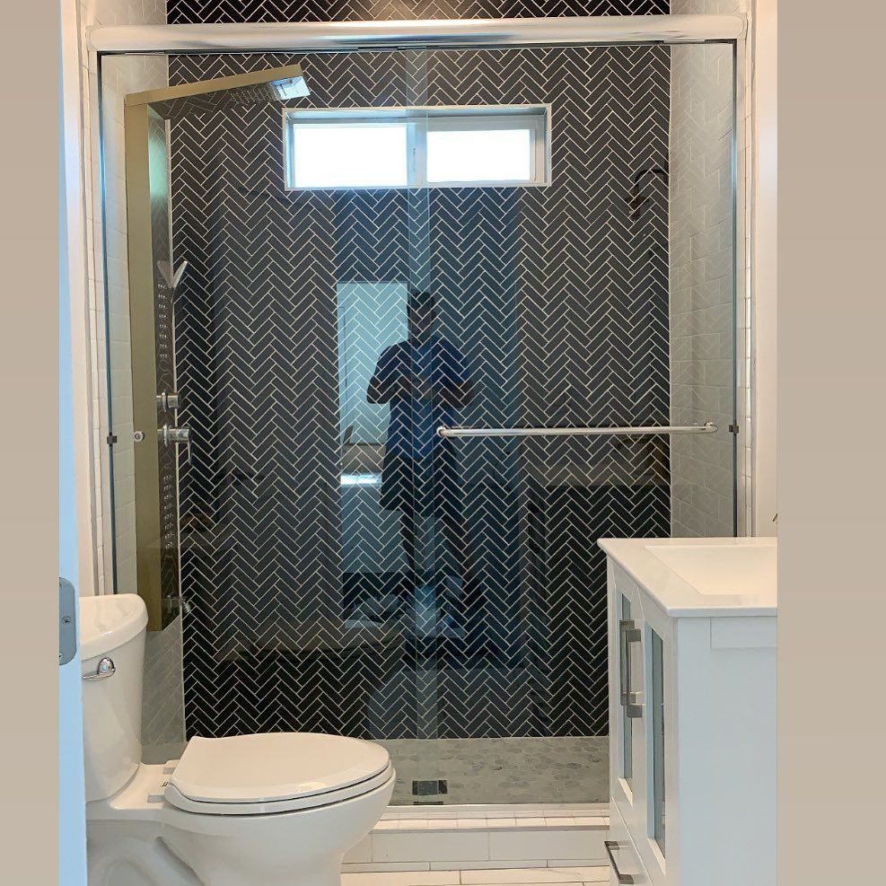 A bathroom with a toilet, sink and shower with a sliding glass door.