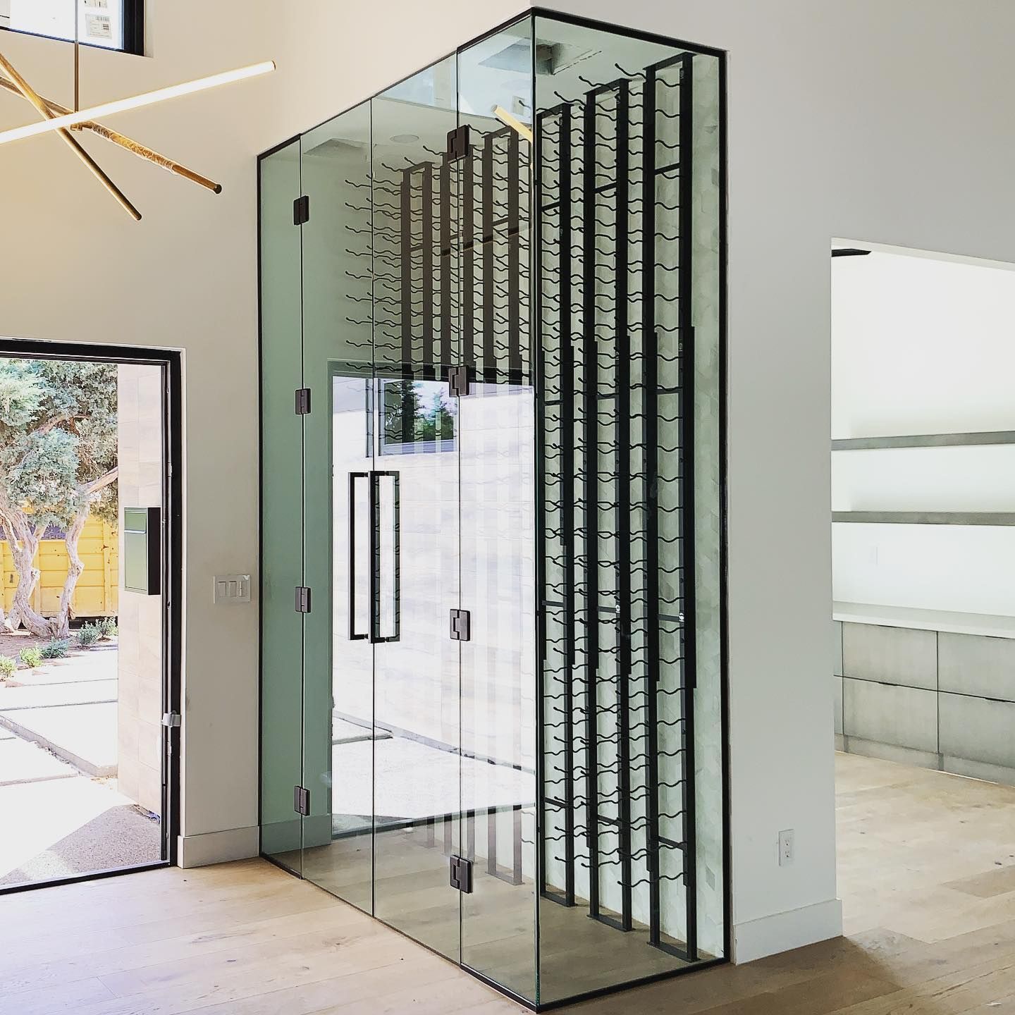 A glass cabinet filled with lots of wine bottles