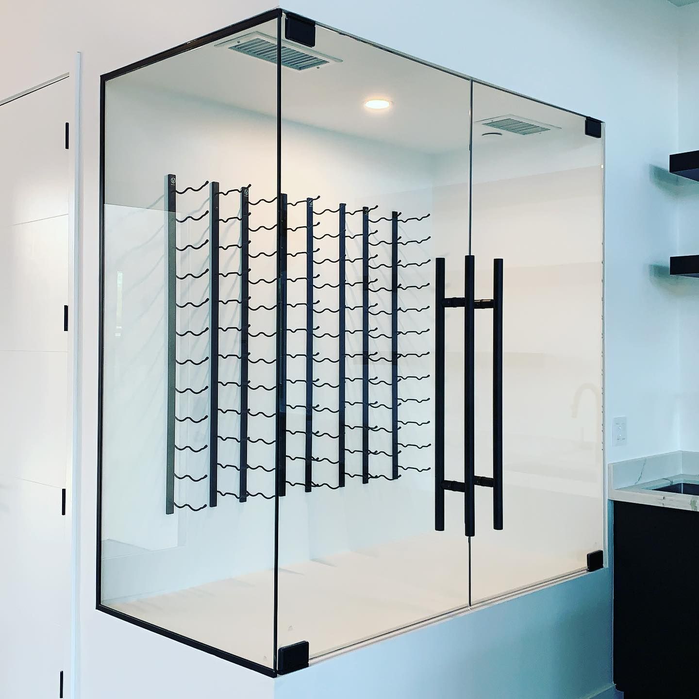 A glass wall with a wine rack inside of it