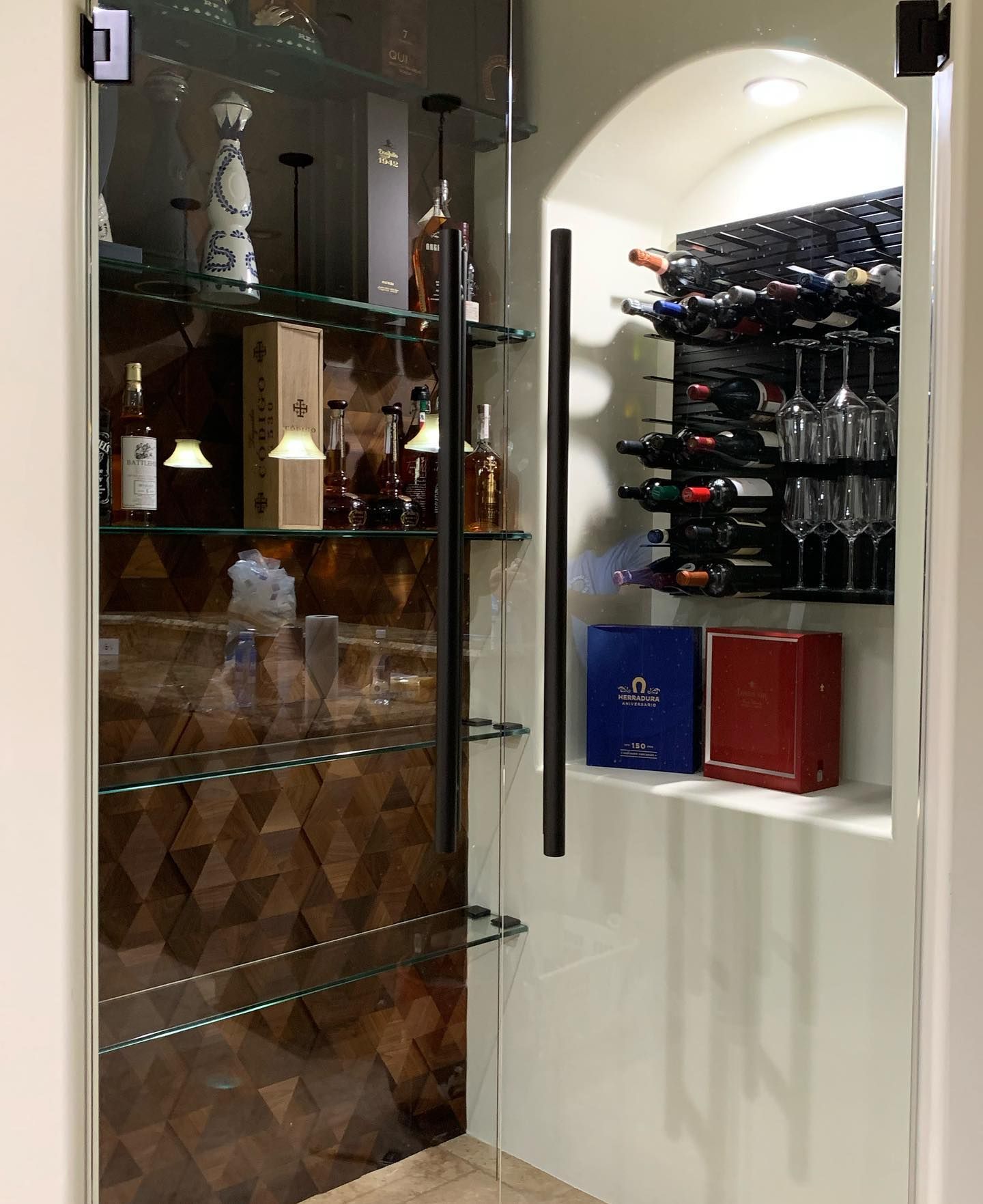 A wine cellar with bottles and glasses on shelves