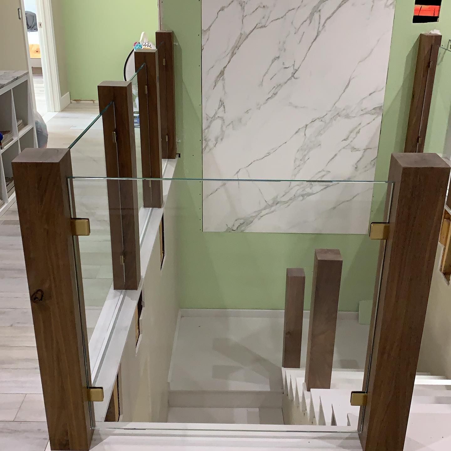 A staircase with a glass railing and wooden posts